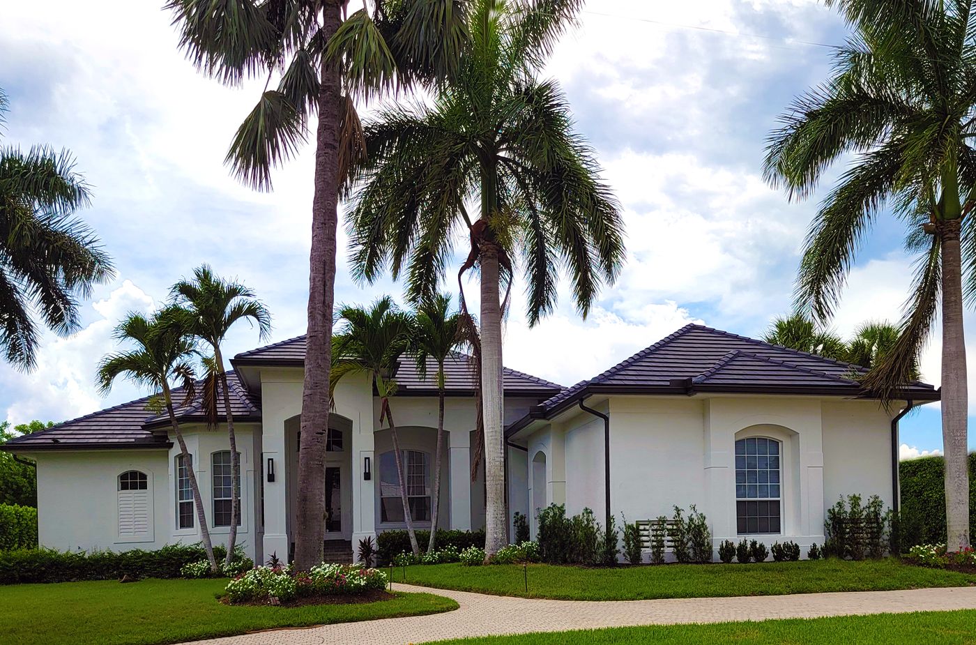 Bright Florida home surrounded by tropical landscaping and palm trees