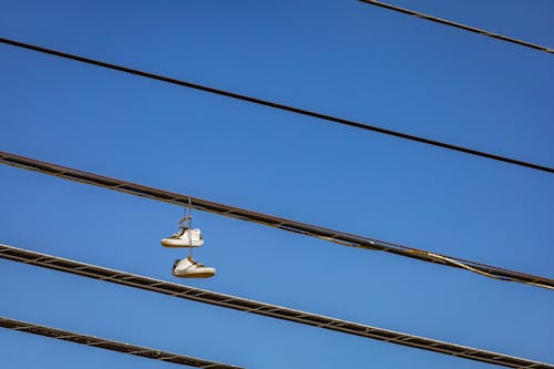 White and Gray Shoes Hanging on Electric Wire