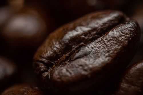 Free Detailed macro shot highlighting the texture of a roasted coffee bean. Stock Photo