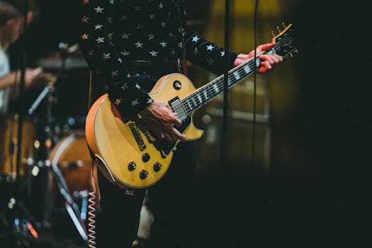 Close-up of a guitarist performing live with a yellow electric guitar.