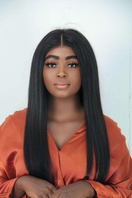Free Stylish studio portrait of a beautiful young woman with long hair in an orange outfit. Stock Photo