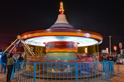 Free People Riding on Carousel during Night Time Stock Photo