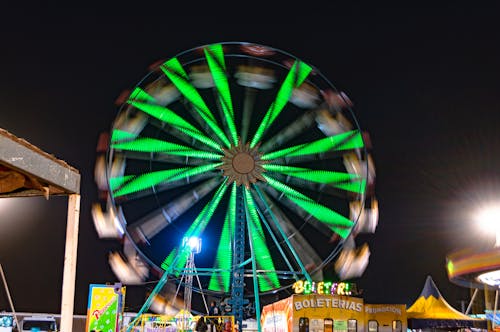 A Spinning Ferris Wheel with Lights during Night Time