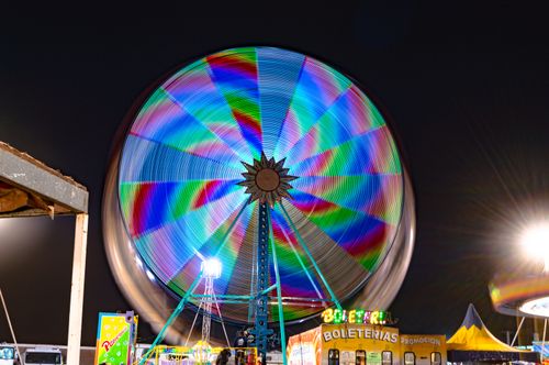 Free Colorful Ferris wheel spinning at night, showcasing vibrant light trails in an amusement park. Stock Photo