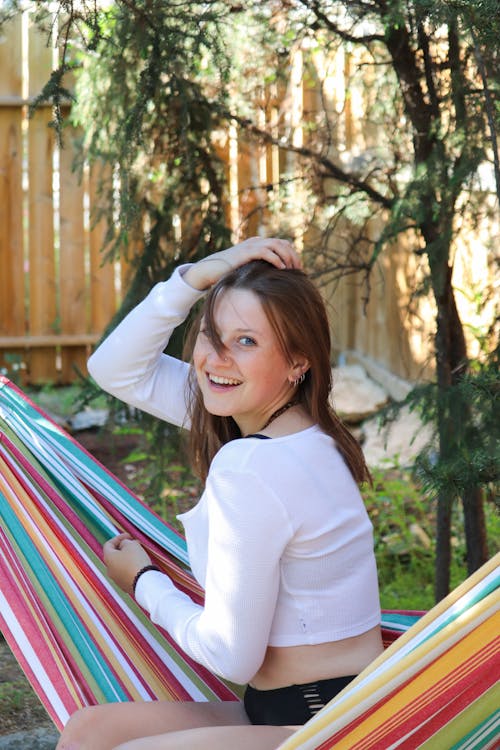 A Woman in White Long Sleeve Sitting on a Hammock