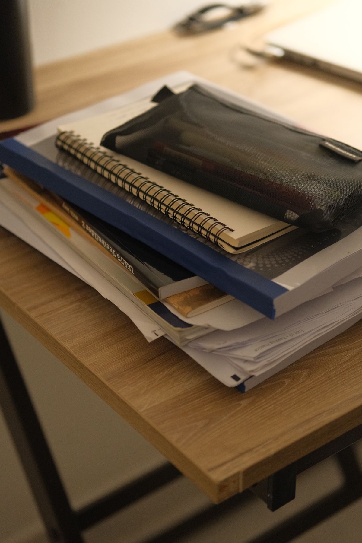 A notebook and a stack of books on a table