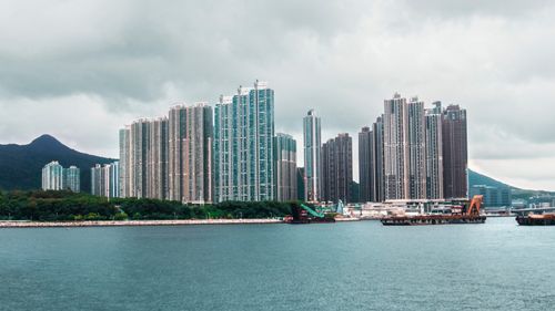 Free Skyscrapers rise along the coastline with mountains in the background. Stock Photo