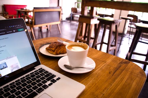 A cup of coffee latte while working on a laptop in a cafe