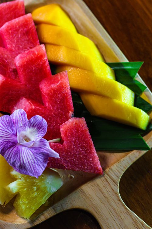 Free Vibrant tropical fruit slices with a decorative orchid in Thailand. Stock Photo