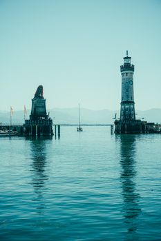Beautiful view of Lindau Lighthouse and Bavarian Lion against the serene lake and mountains.