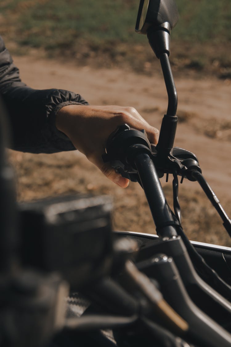 A Hand Gripping The Throttle Of A Vehicle
