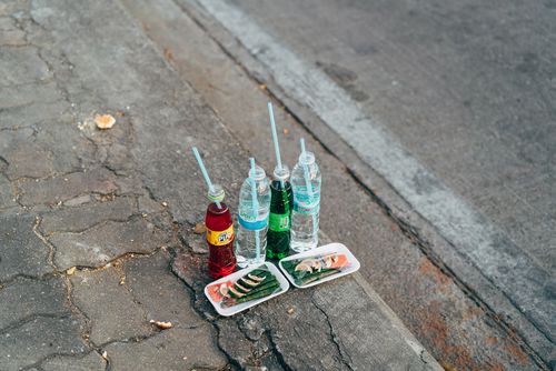 Free Traditional Thai offerings with drinks and snacks laid out on a Bangkok street sidewalk. Stock Photo