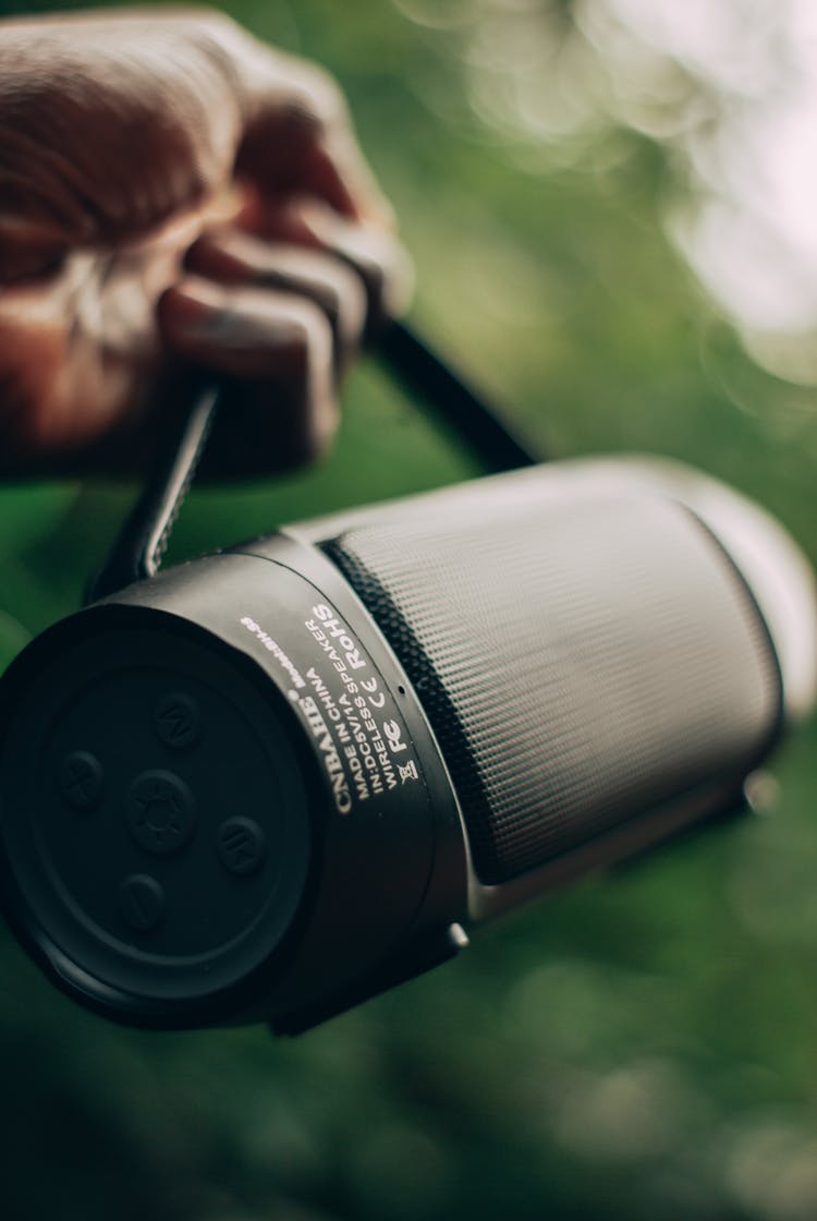 A Person Holding A Bluetooth Speaker