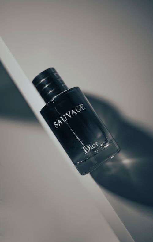 Free Stylish product shot of Dior Sauvage perfume bottle highlighting luxury and elegance on a white surface. Stock Photo