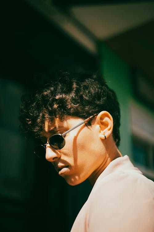 Portrait of a Young Man with Curly Hair Wearing Sunglasses