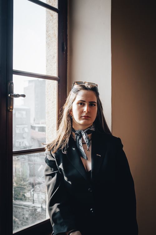 Free Portrait of a woman posing by a window in İzmir, Turkey, showcasing style and confidence. Stock Photo