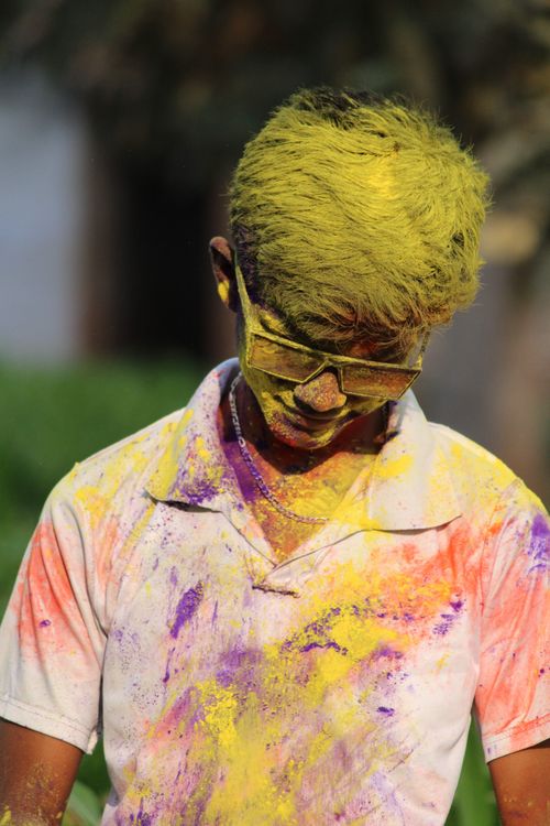 Free Young man covered in colorful powders during Holi festival, enjoying the vibrant celebration. Stock Photo