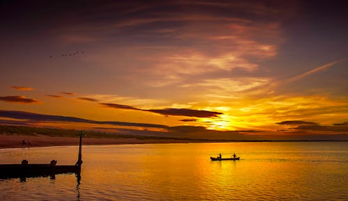 Silhouette of Boat on Sea during Sunset