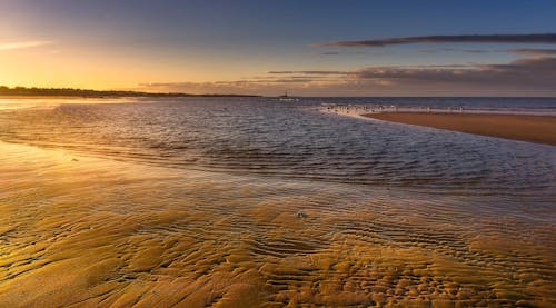 Sea Waves Crashing on Shore During Sunset