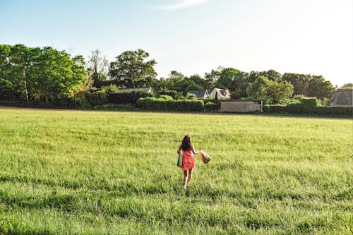 Woman Running on Grass Field