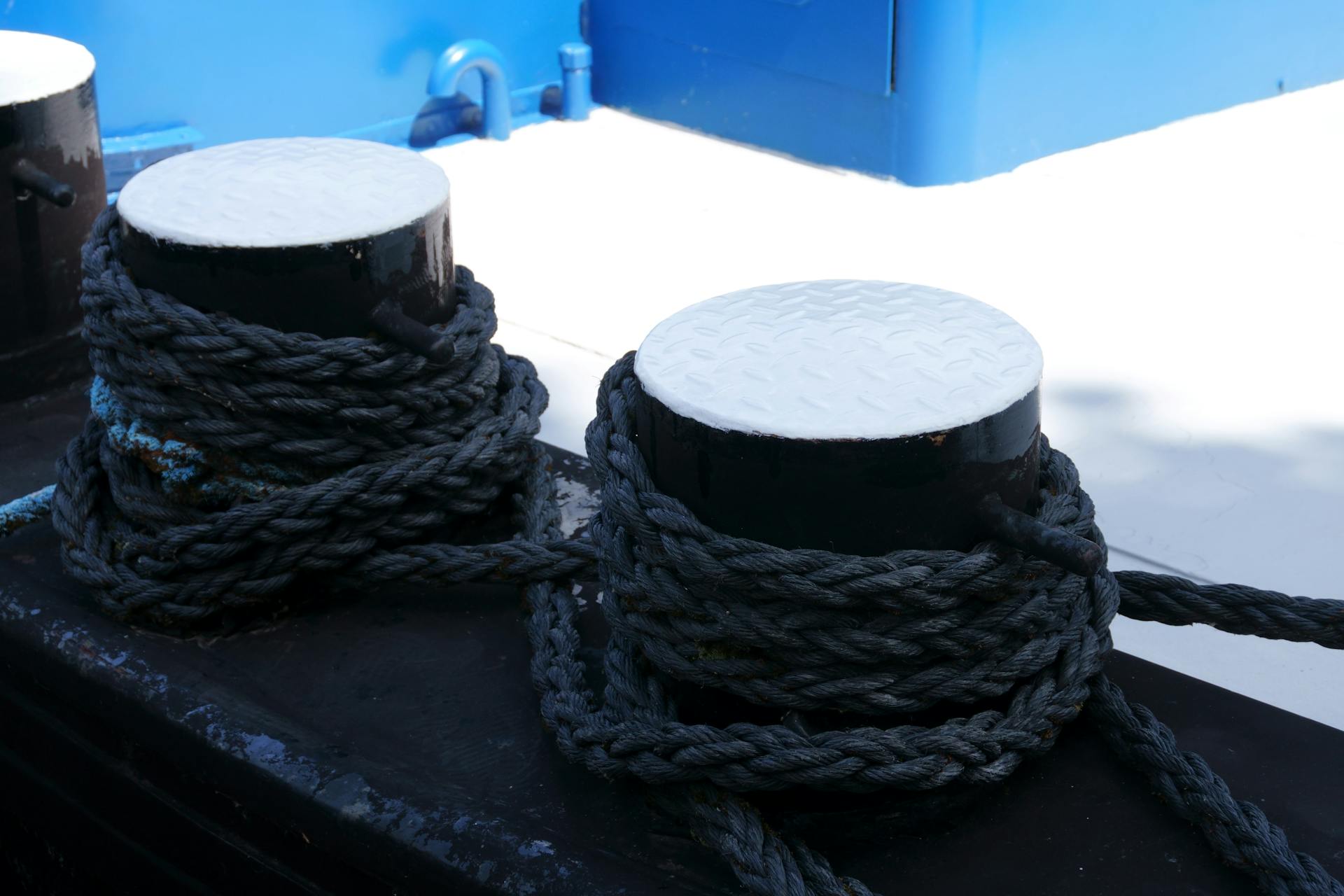 Detailed view of ropes wrapped around bollards on a ship's deck in België.