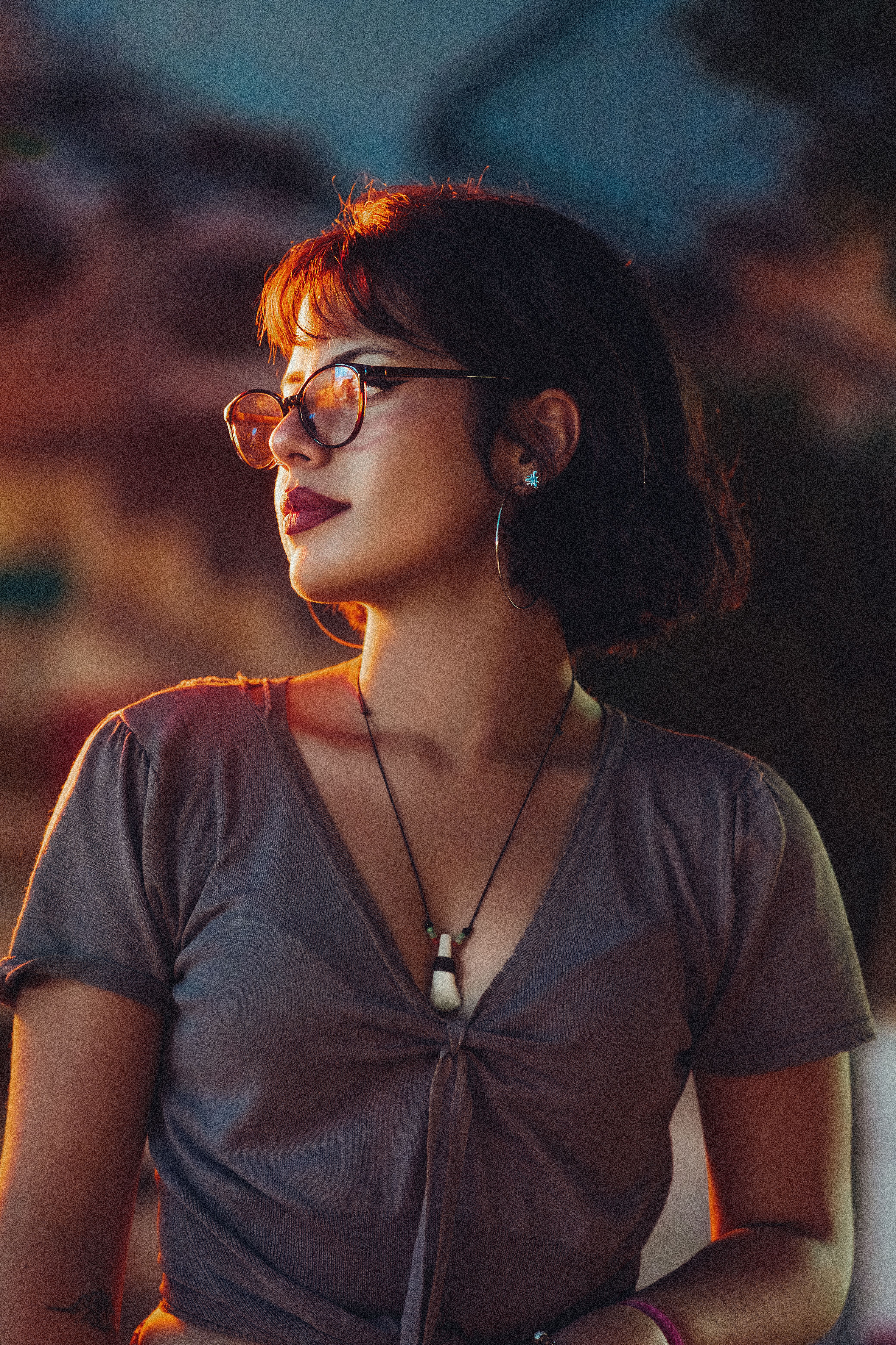 A stylish woman with eyeglasses captured in a thoughtful pose during twilight, showcasing elegance a