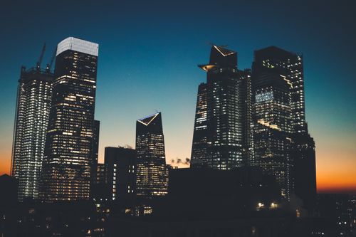 Free Dramatic view of New York City's skyline with illuminated skyscrapers at sunset. Stock Photo