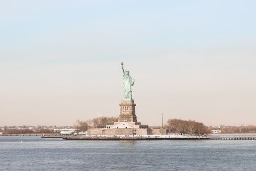 Free Iconic Statue of Liberty overlooking the New York City harbor, symbolizing freedom and democracy. Stock Photo