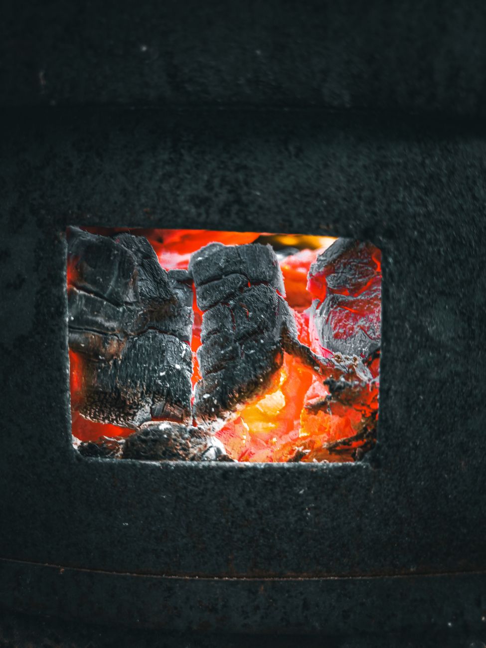 Glowing coals inside an offset smoker firebox