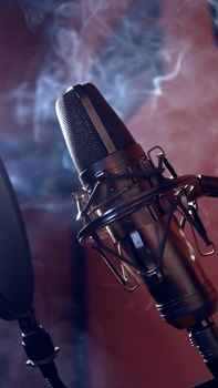 Close-up of a studio microphone with a dramatic smoke background, perfect for music production themes.