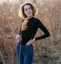 Woman in Black Long Sleeve Shirt and Blue Denim Jeans Standing on Brown Grass Field during