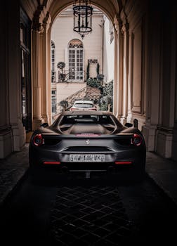 Stunning rear view of a Ferrari 488 GTB under a historic Parisian archway, highlighting urban luxury.