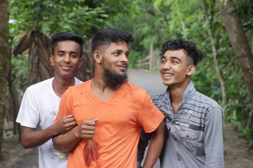 Free Three happy friends walking outdoors, smiling and enjoying a pleasant day together. Stock Photo
