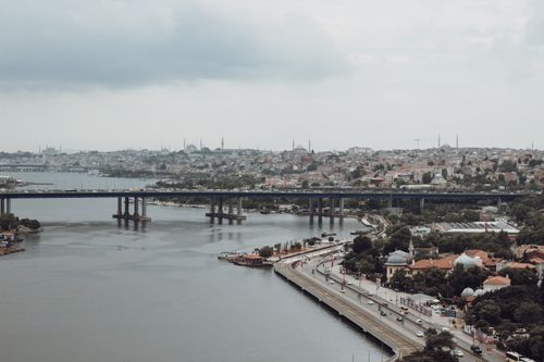 Free Drone shot capturing the bustling cityscape of Istanbul with a prominent bridge over calm waters. Stock Photo