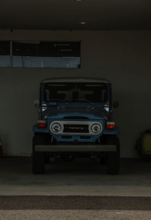 Free Front view of a vintage Toyota SUV parked inside a dimly lit garage. Stock Photo