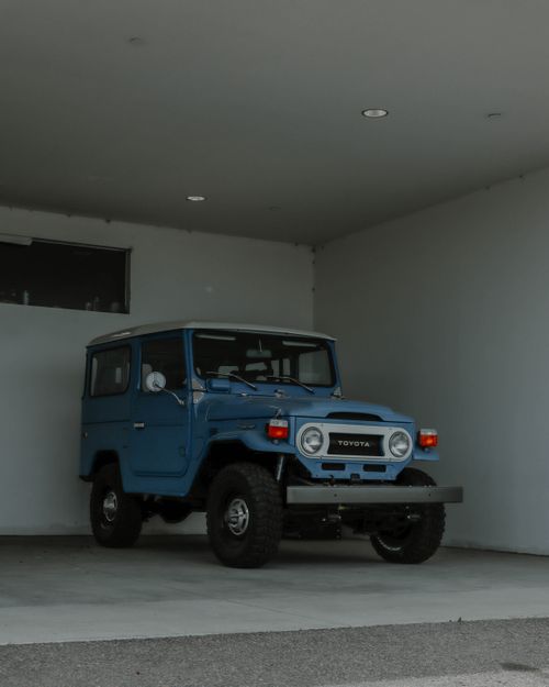 Free Classic blue Toyota Land Cruiser parked in a minimalist garage interior. Stock Photo