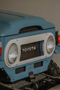 Detailed view of a vintage Toyota Land Cruiser's front grille and headlights.