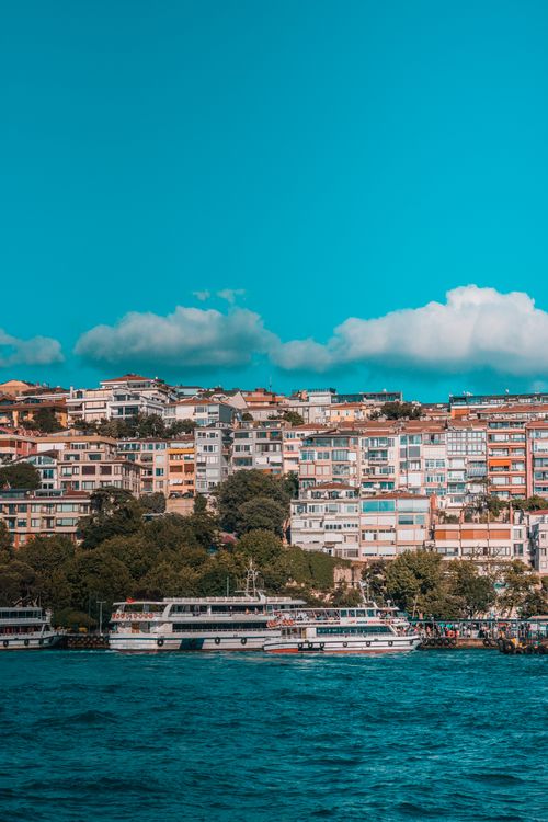 Free A colorful view of Istanbul's waterfront with residential buildings and ferries on a sunny day. Stock Photo