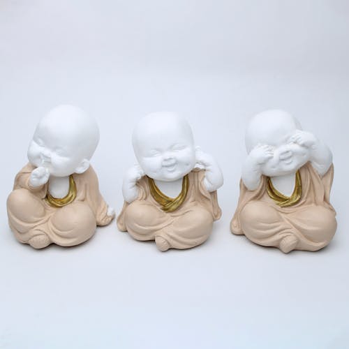 2 White Ceramic Figurines on White Surface