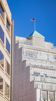 Contemporary city buildings with an American flag and blue sky.