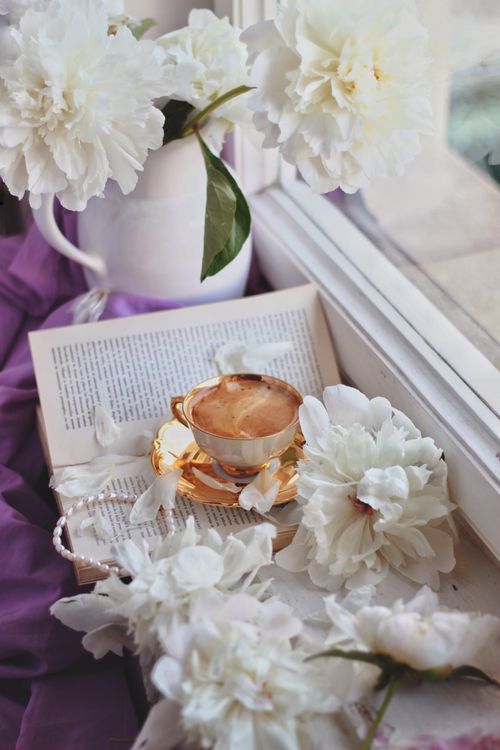 Free A cozy scene with coffee and white flowers by a window for a relaxing vibe. Stock Photo
