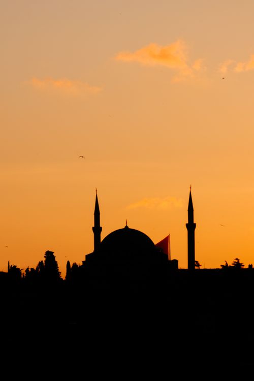 Free Silhouette of a mosque with minarets and a golden sky at twilight. Stock Photo