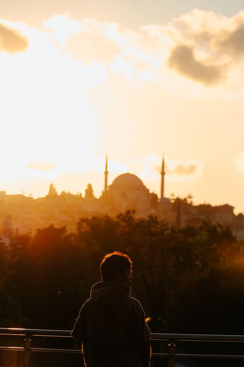 Free A silhouette of a mosque and a person against a dramatic sunset sky, symbolizing spirituality. Stock Photo