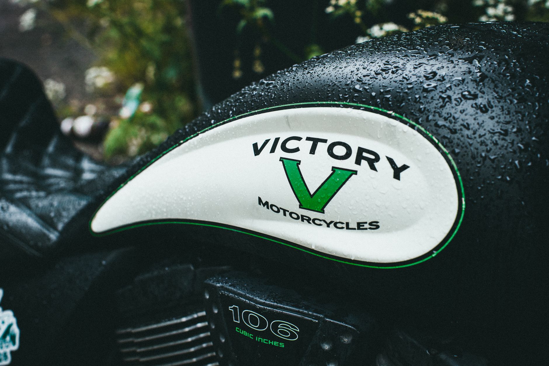 Detailed shot of a Victory motorcycle tank with rain droplets highlighting its design.