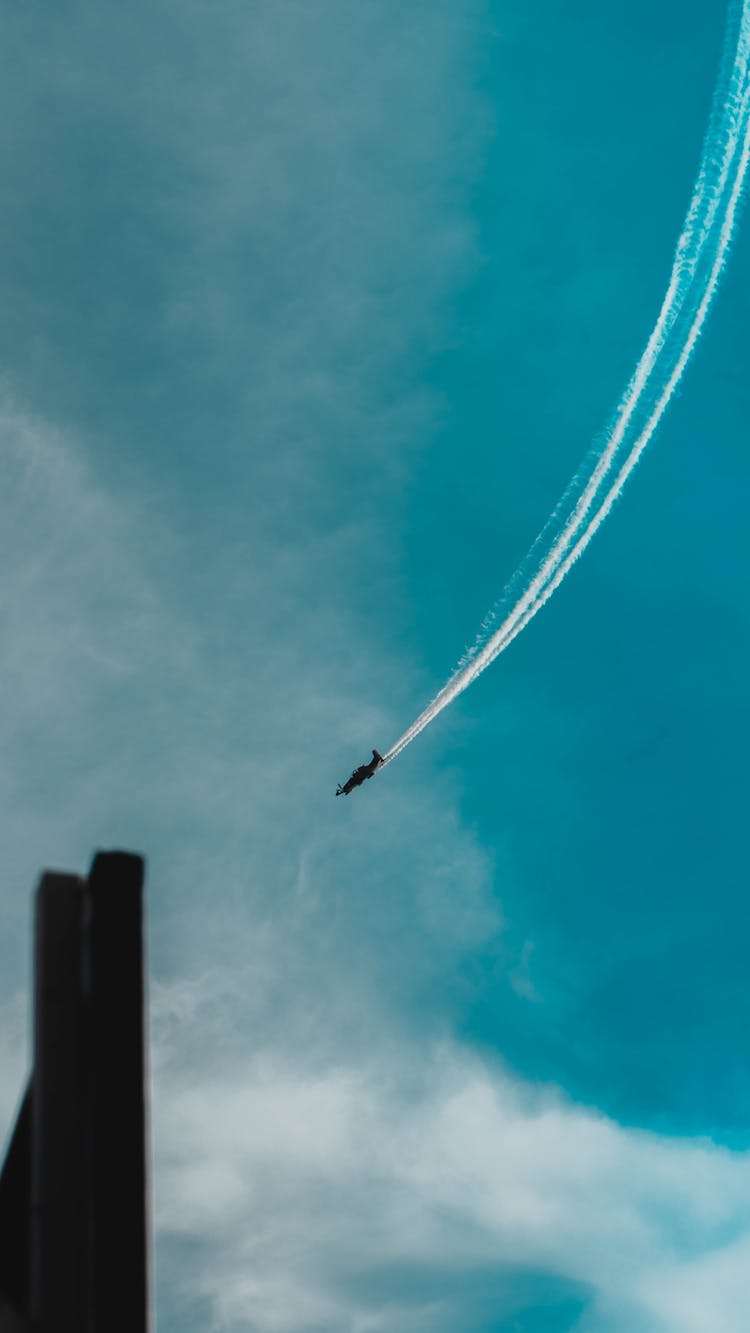 Plane Flying And Leaving A Vapor Trail Behind 