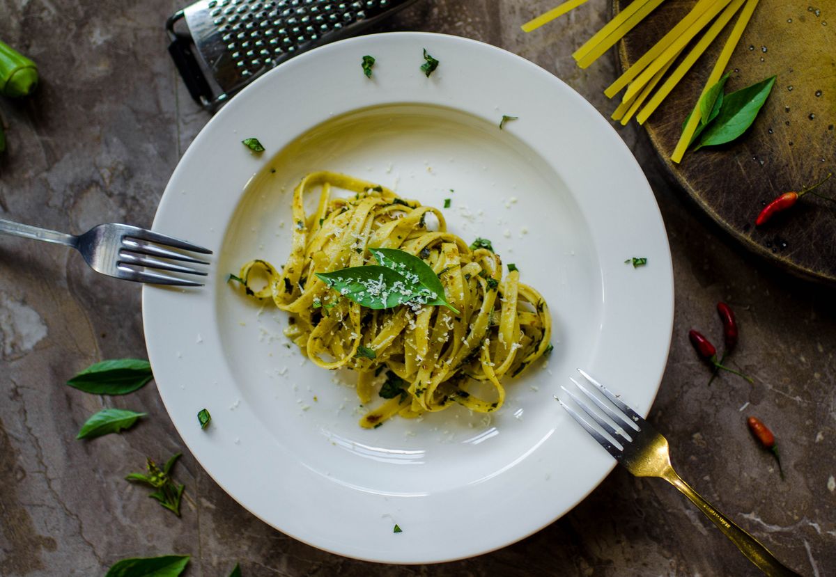 Tagliatelle ribbons tossed in green pesto with basil