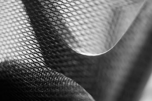 Detailed close-up of black and white mesh fabric showcasing intricate patterns and texture in monochrome.