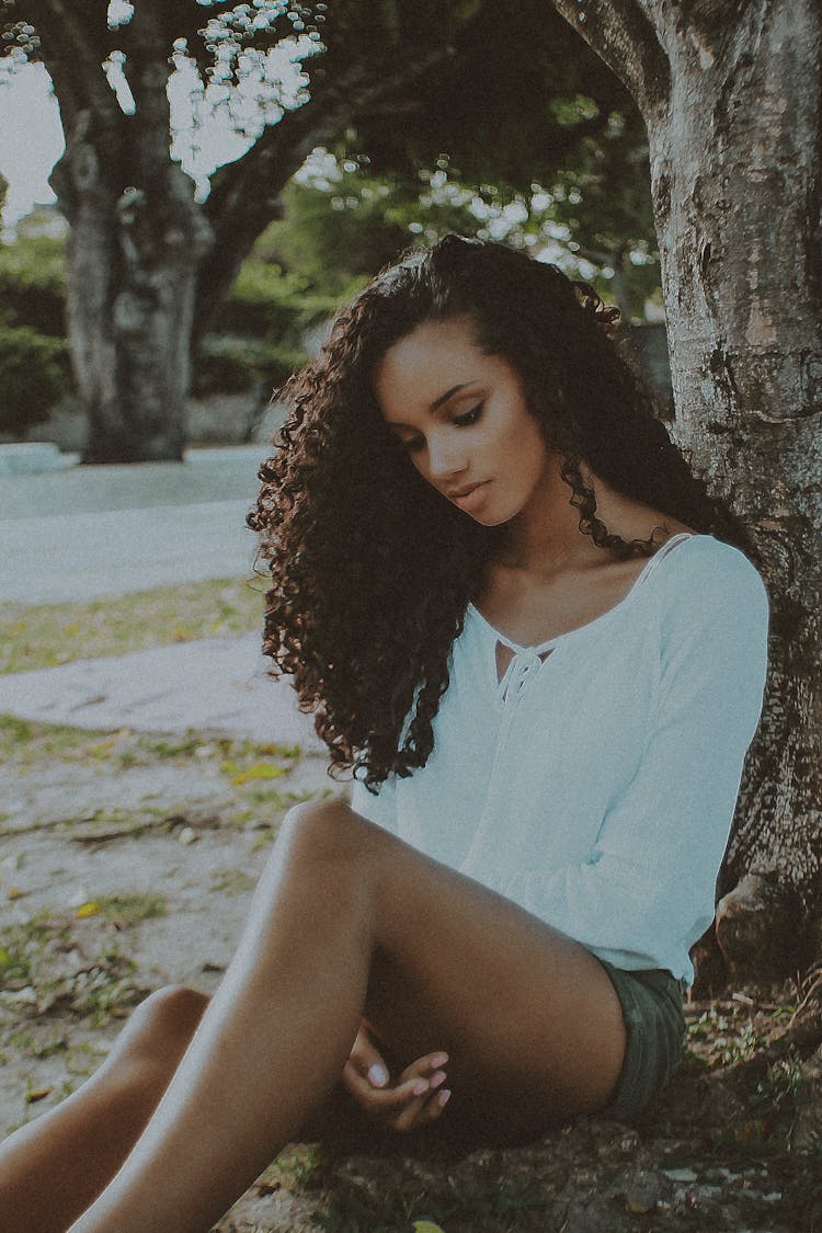 Woman Sitting In Front Of Tree