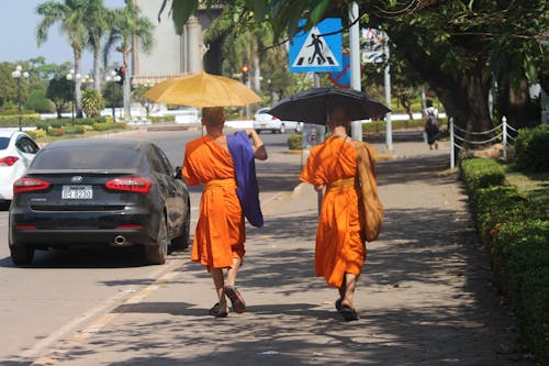 Photo of Monks Holding an Umbrella