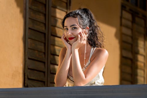 Free Woman in White Tank Top Sitting on Brown Wooden Bench Stock Photo